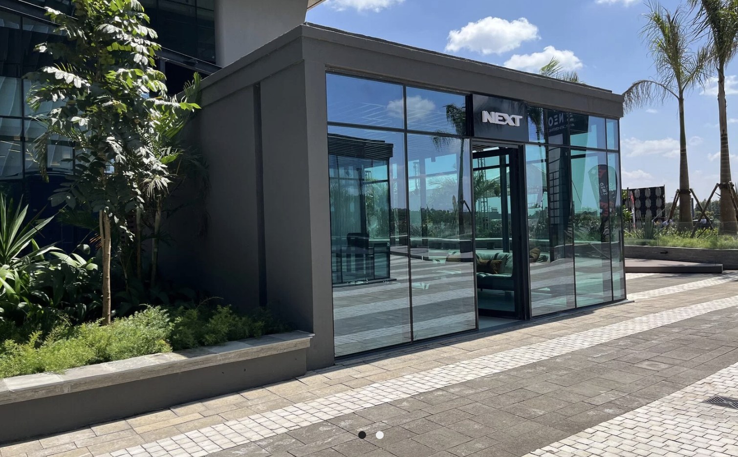 Glass entrance with NEXT signage at the Tatu City sales office